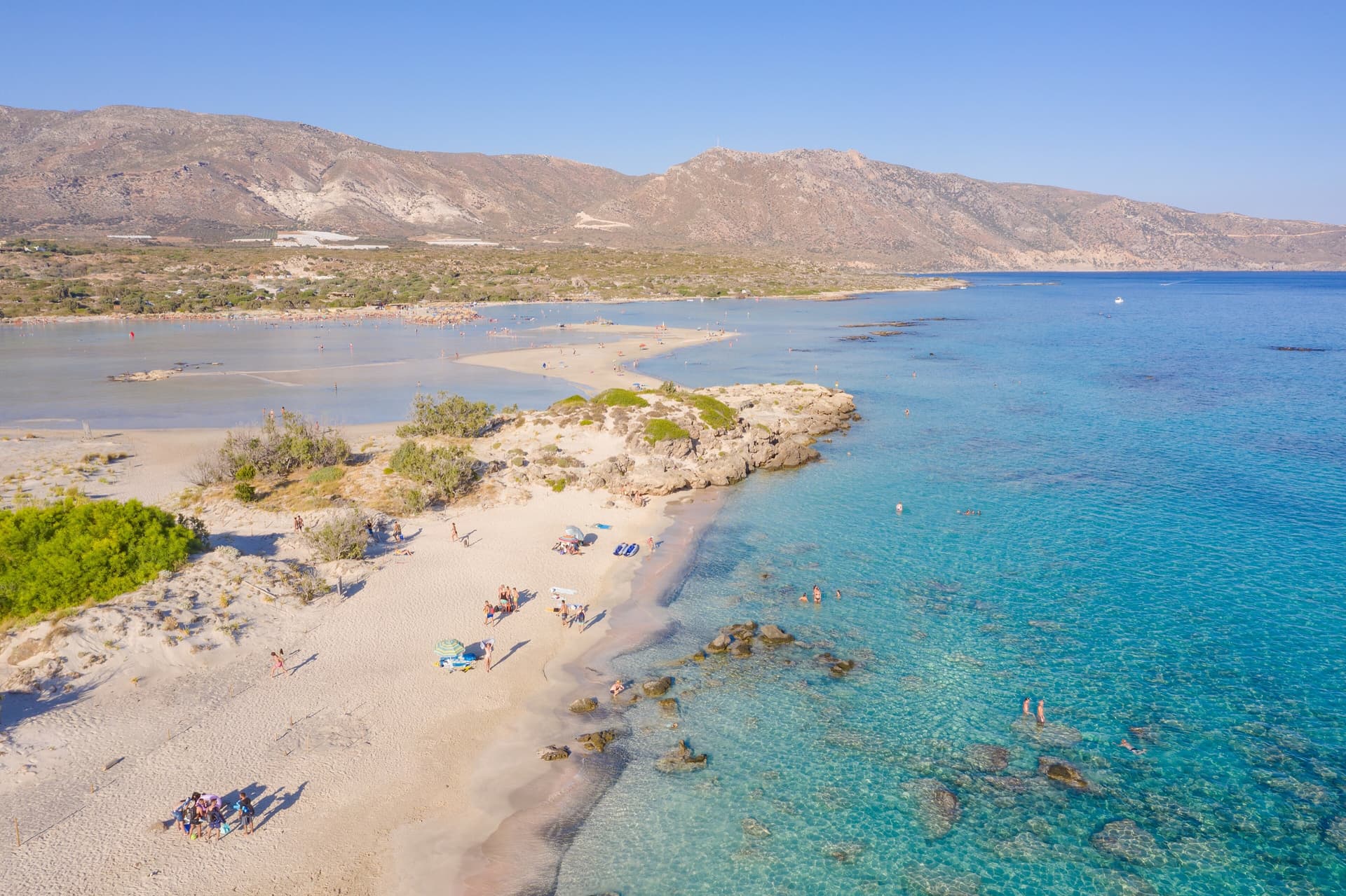 Elafonissi's clear lagoon, pale sand and western-Crete mountain horizon in daylight