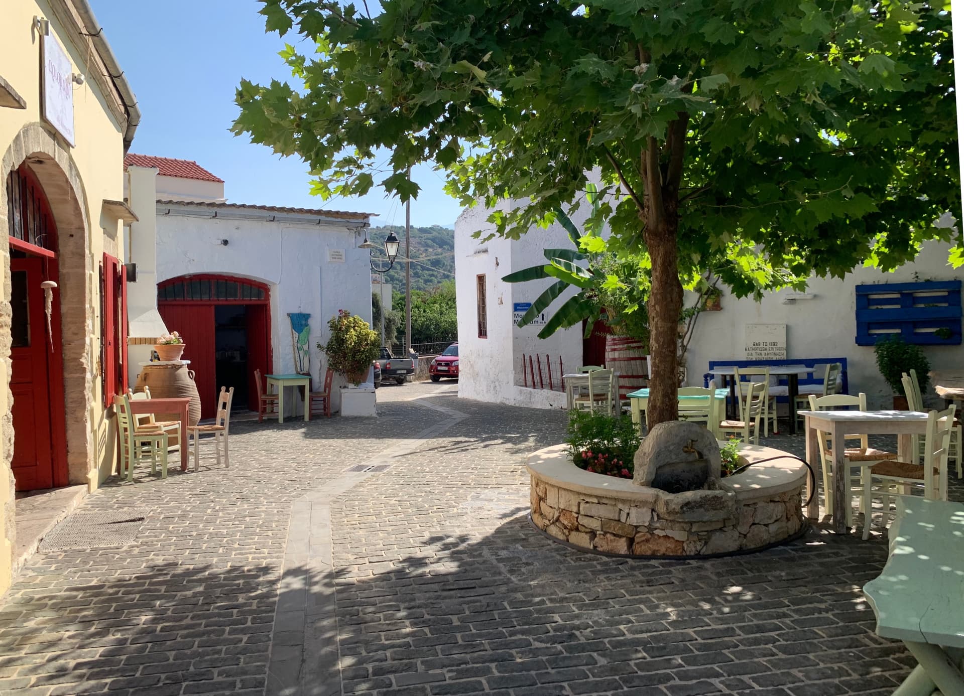 Leafy village square with a stone spring and shaded tables in Gavalochori, Apokoronas
